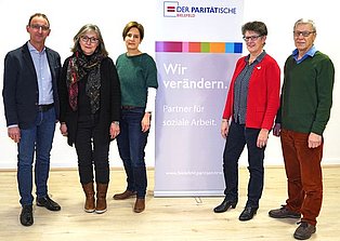 5 Personen um ein Roll up des Paritätischen NRW