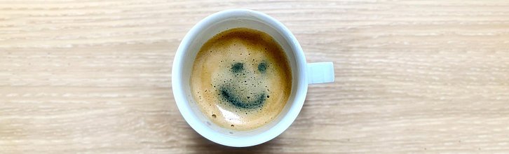 Tasse mit Kaffee; in der Crema ist ein Smiley